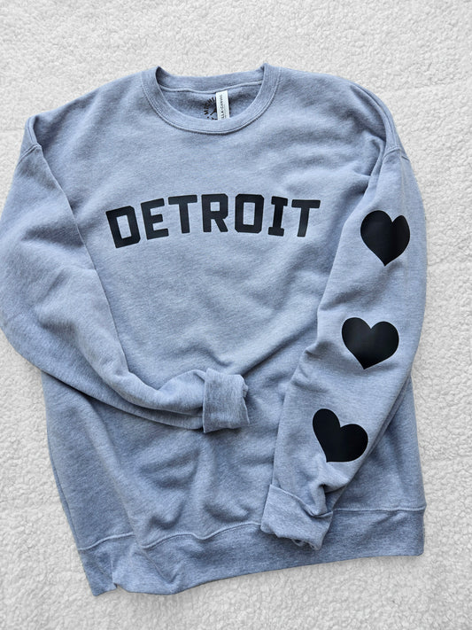 Detroit sweatshirt with black hearts. Fleece crew sweatshirt with Detroit logo and black hearts on the left sleeve.